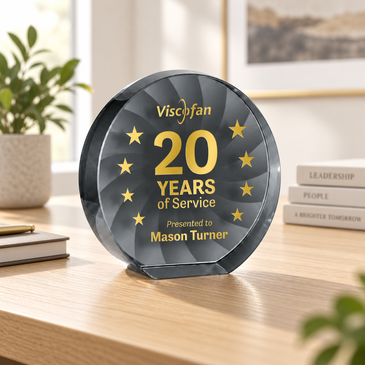 Years-of-service award displayed on a light wood office desk